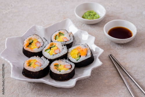 Maki sushi rolls on white plate with soy sauce and wasabi-Japanese food