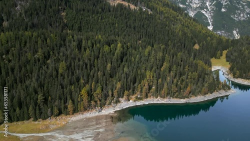 Drone shot of the Obernberger Lake lakeside in Austrias Tyrol with very clear blue water and reflections of the mountains photo