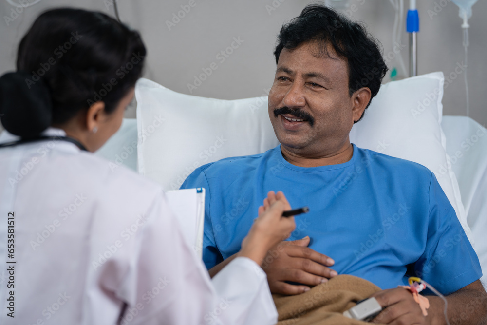 Obraz premium Shoulder shot of indian doctor consoling sick admitted recovered patient by giving confidence at hospital - concept of medical support, Encouragement and reassurance.