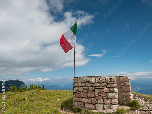 Italian flag at Canfedin view. Summer meadow close to peak of Gazza mountain