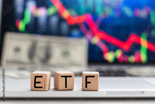 On a light background, graphs, charts and wooden cubes with the inscription ETF - Exchange Traded Fund. photo