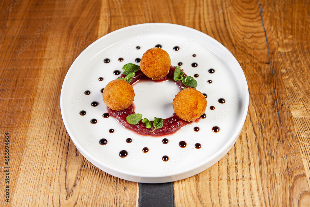 restaurant dish on a wooden table, cheese balls, cranberry sauce restaurant dish on a wooden table, cheese balls, cranberry sauce