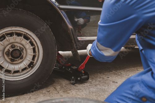 Car mechanic is inspecting tires and replacing worn tires through long hours of work, car repairs, car breakdowns, punctured tires. Concept of car tire maintenance and car repair.