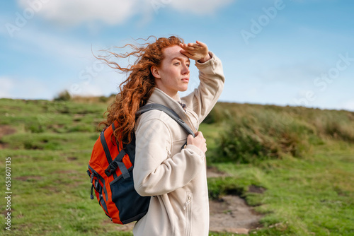 amazed Woman in jacket reaching the destination and taking selfie and shouting on the top of mountain at sunset. Travel Lifestyle concept The national park Peak District in England