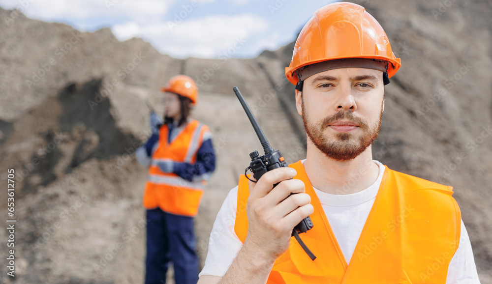 Industrial worker man use walkie talkie, team engineers control sand quarry. Concept open pit mine industry banner Industrial worker man use walkie talkie, team engineers control sand quarry. Concept open pit mine industry banner