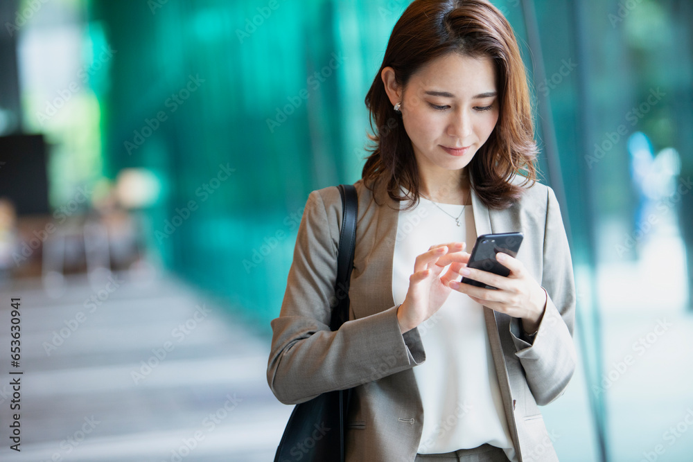 スマホを見ているビジネスウーマン スマホを見ているビジネスウーマン