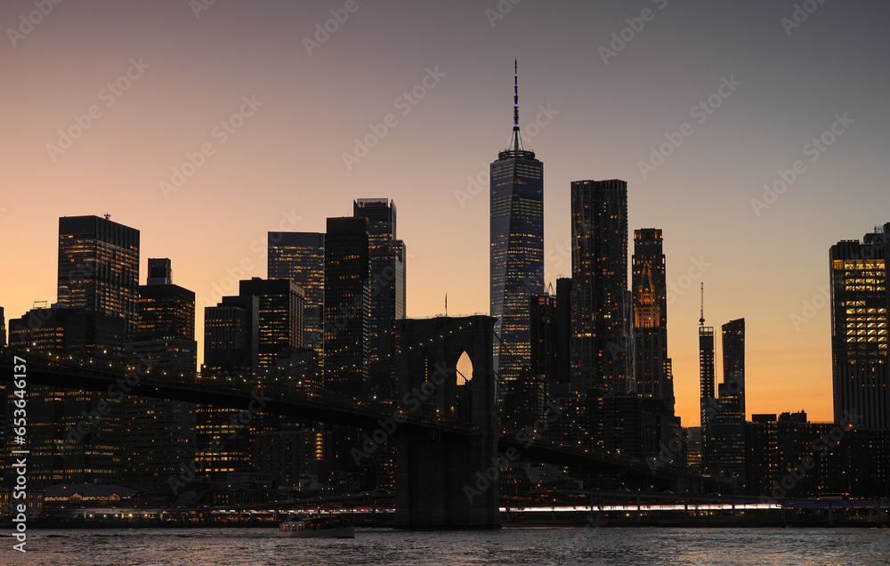 Fototapeta premium Landscape in Manhattan. The silhouettes of modern skyscraper office buildings from New York during a beautiful summer sunset. Travel to America.