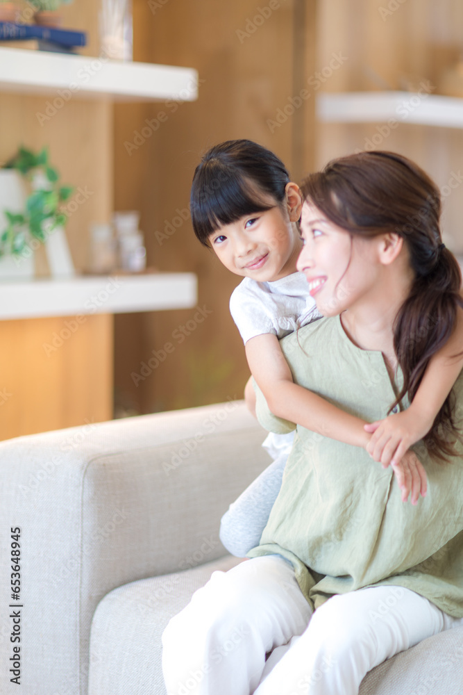 ソファーで戯れる母親と娘 ソファーで戯れる母親と娘
