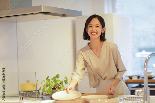 キッチンで食器を片付ける30代女性 photo