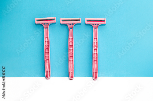 Pink lady shavers  razors on white  blue background