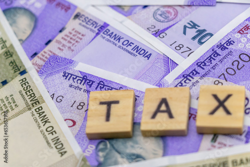 Close up shot of money with defocused tax word on wood chips.