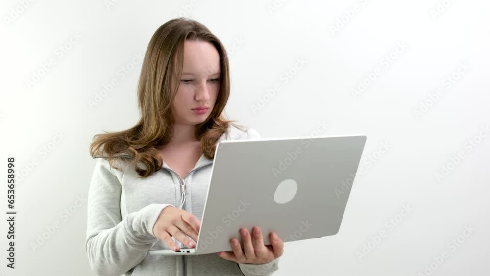 Image of a young blonde woman sitting on a white surface with a laptop in her lap. High quality photo Image of a young blonde woman sitting on a white surface with a laptop in her lap. High quality photo