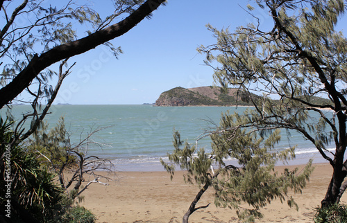 View of Kemp Beach with the ocean and sand framed by trees in Yeppoon, Queensland, Australia