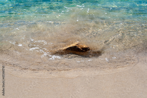 Sand and clear water with rock