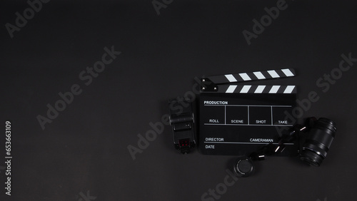 Clapperboard or movie slate with film,lens,flash light.It is used in video production , cinema industry on black background.