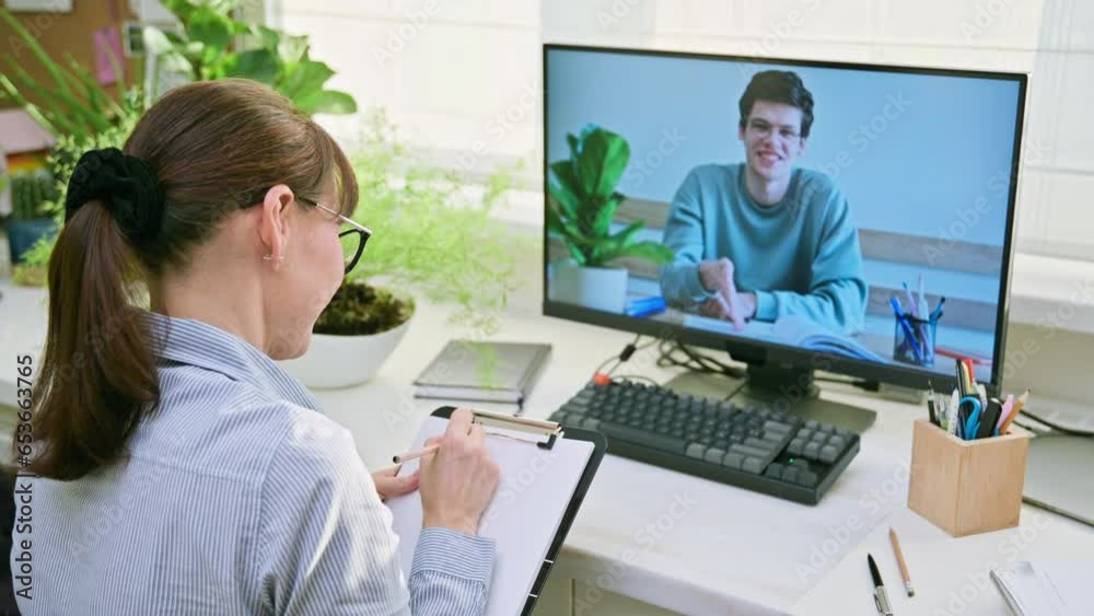 Female teacher teaching online guy student, video conference on computer screen Female teacher teaching online guy student, video conference on computer screen