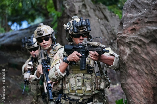 Fototapet Military army soldiers tactical team, commando group moving cautiously in forest area, kneeling and looking around, covering comrades, controlling sectors
