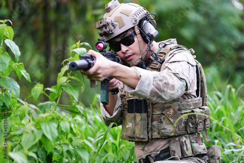 Military army soldiers tactical team, commando group moving cautiously in forest area, kneeling and looking around, covering comrades, controlling sectors. Commander showing halt or stop hand signal