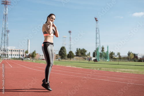 Beautiful woman training on the tracks on a sunny morning 