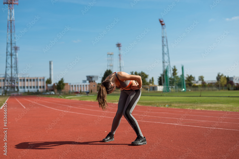 Beautiful woman training on the tracks on a sunny morning
