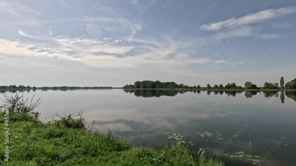 reflection of trees and clouds in water of danube reflection of trees and clouds in water of danube