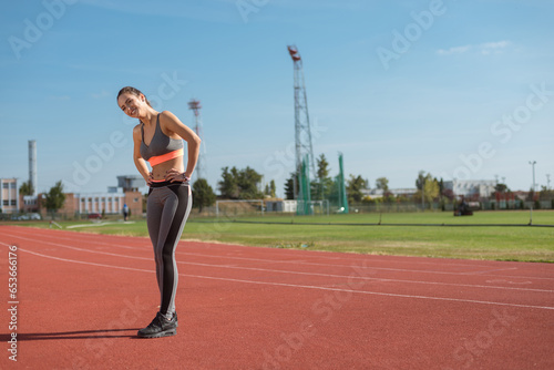 Beautiful woman training on the tracks on a sunny morning 