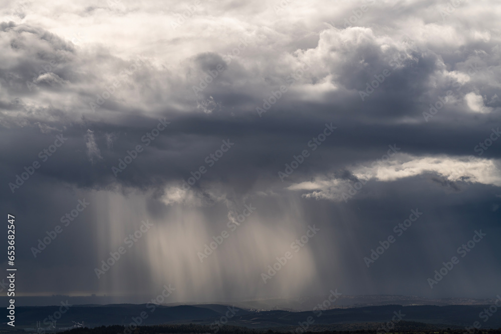 Sun rays shining through rainclouds showing the falling rain in Northern Israel looking towards the Mediterranean Sea from Muhraqa viewpoint.
Sun rays shining through rainclouds showing the falling rain in Northern Israel looking towards the Mediterranean Sea from Muhraqa viewpoint.