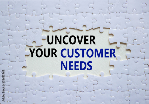 Customer Needs symbol. White puzzle with words Uncover your Customer Needs. Beautiful white background. Business concept. Copy space.