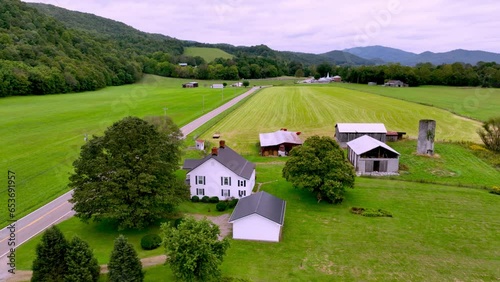 aerial push over farmhouse and farm in rural mountain city tennessee photo