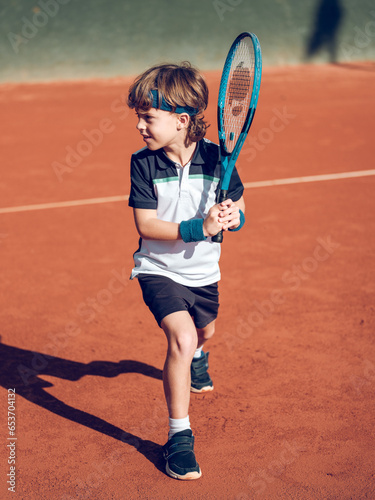 Preteen boy preparing for stroke with tennis racket © ADDICTIVE STOCK CORE