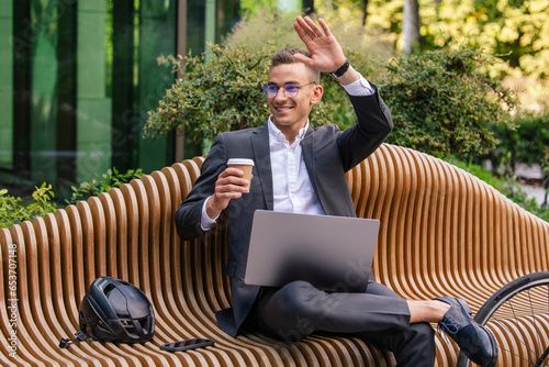 Handsome young businessman working on laptop and drinking coffee photo