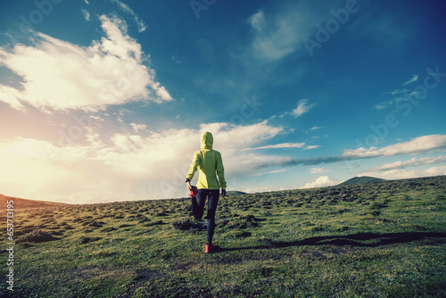 Woman trail runner cross country running at high altitude mountain peak
