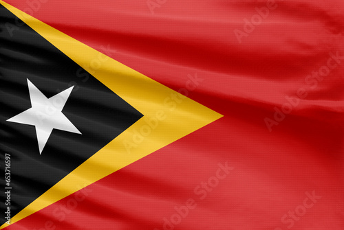 East Timor flag is depicted on a sport stitch cloth fabric with folds.