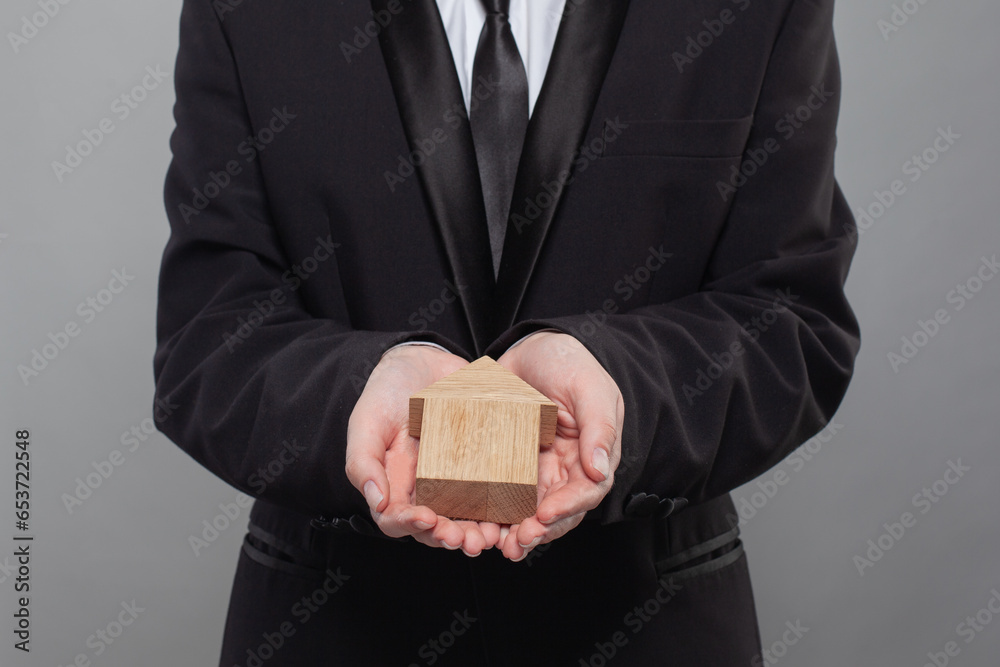 Human hand holding wooden home. Real estate insurance, rent and property concept Human hand holding wooden home. Real estate insurance, rent and property concept