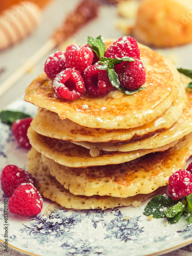 Appetizing pancakes with raspberries and honey