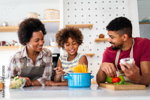 Happy african american family preparing healthy food in kitchen  having fun together on weekend