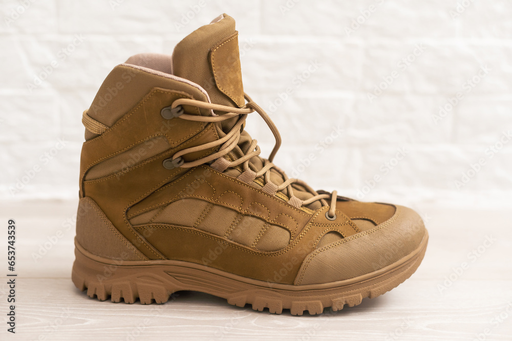 Fashion shoes with rough tread. Beige leather boots on laces for street style isolated on white background