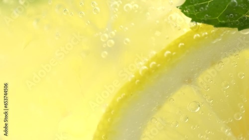 Lemonade in a glass, macro. Fruit lemon cocktail close-up texture, healthy sweet drink. Detox drink, summer refreshment concept. photo