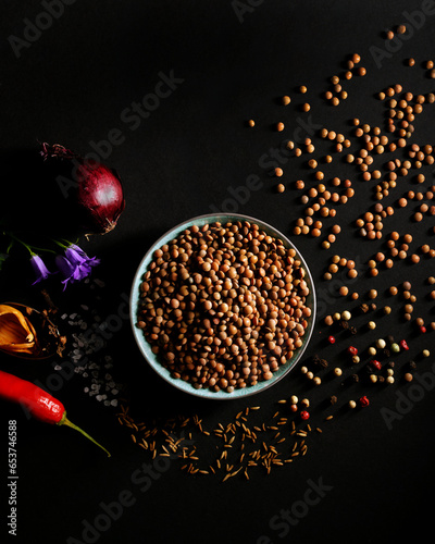 Lentils and herbs for an Indian dal, on a black background