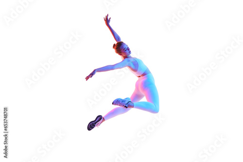 Fitness portrait of young woman dressed sportively doing jumps in motion isolated white background in neon light.