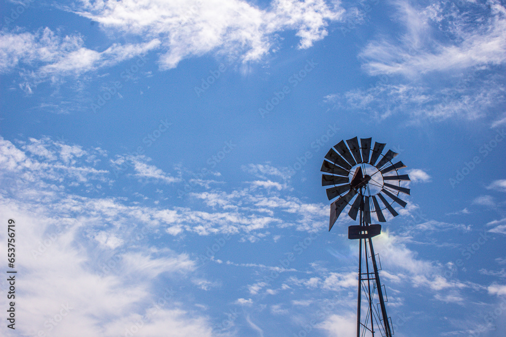 Old metal windmill with blue sky background Old metal windmill with blue sky background