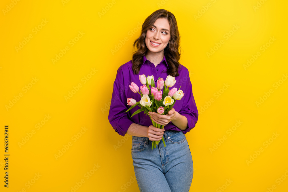 Photo of gorgeous minded lady hold fresh tulip flowers look empty space ad isolated on yellow color background - obrazy, fototapety, plakaty 