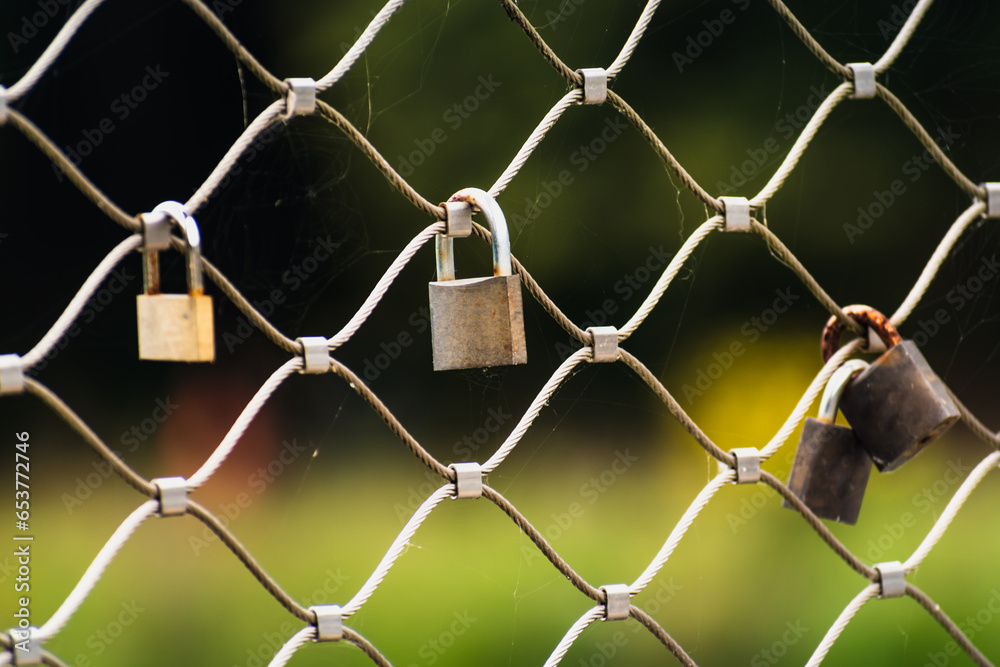Naklejka premium Rusty padlocks attached to the metal railing of a bridge, tradition of padlocks, symbol of eternal love