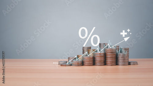 Coins are lined up on a wooden floor along with index charts, arrows and candlesticks. Represents financial, economic, business growth concepts. Financial success concept. Abstract finance background.