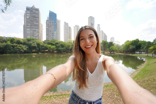 Portrait of beautiful Brazilian girl takes selfie in Areiao Park in Goiania, Goias, Brazil photo