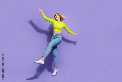 Full length photo of optimistic lovely girl wear stylihs clothes celebratig summer holidays solated on purple color background