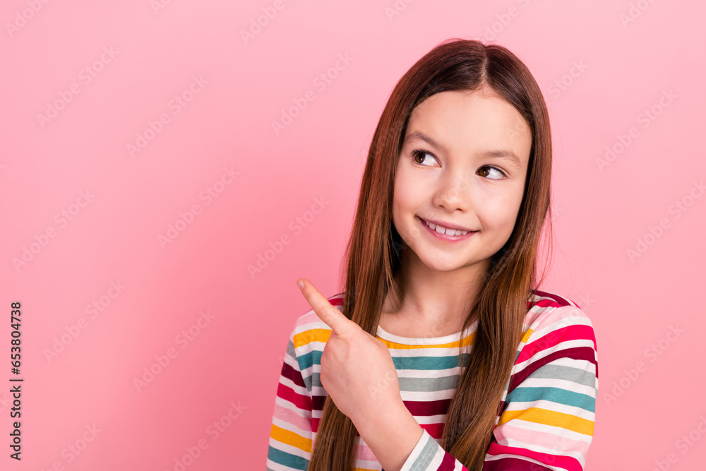 Photo of cheerful toothy smile child indicating finger empty space positive advertisement introduction isolated on pink color background Photo of cheerful toothy smile child indicating finger empty space positive advertisement introduction isolated on pink color background