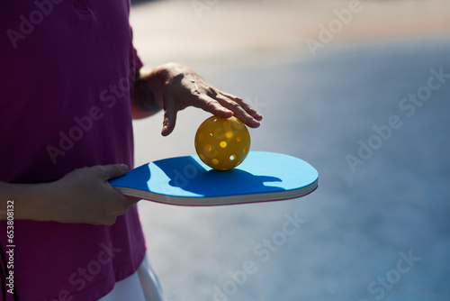 Pickler rolling a plastic ball on a racket photo