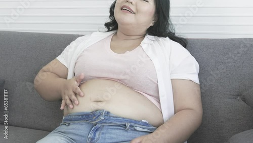 chubby asian woman smacks her belly happily after eating food the pleasure of eating fat woman