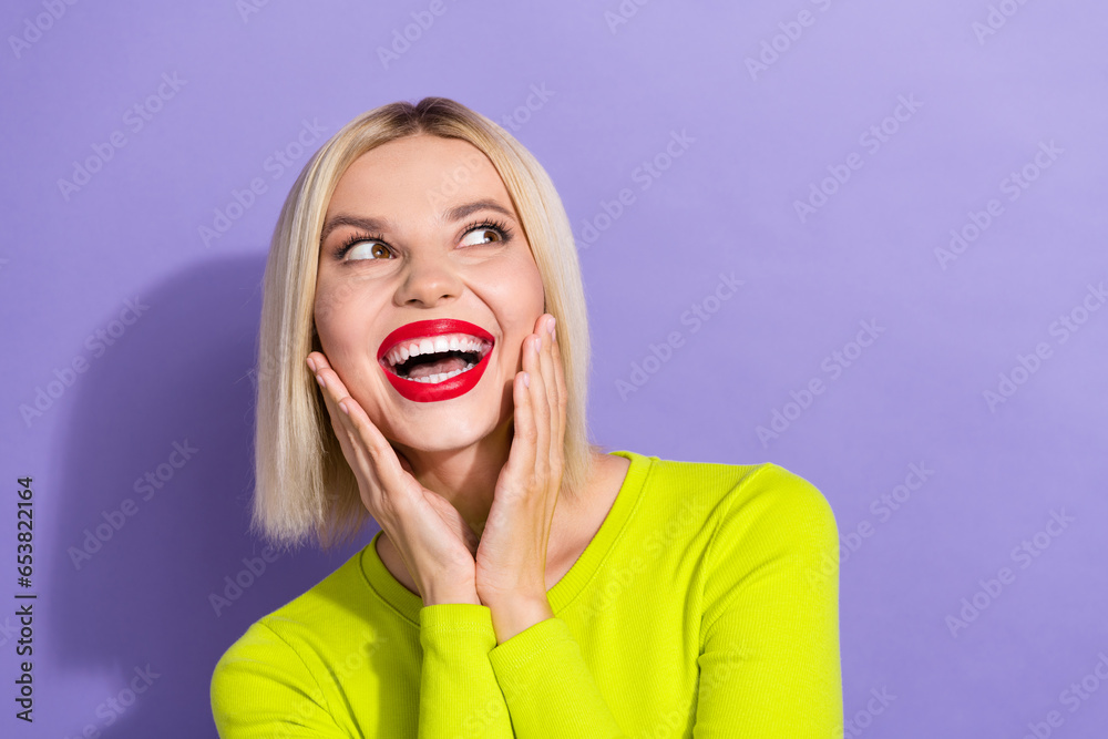 Photo of astonished woman with bob hairstyle dressed yellow clothes hands on cheeks look empty space isolated on purple color background Photo of astonished woman with bob hairstyle dressed yellow clothes hands on cheeks look empty space isolated on purple color background